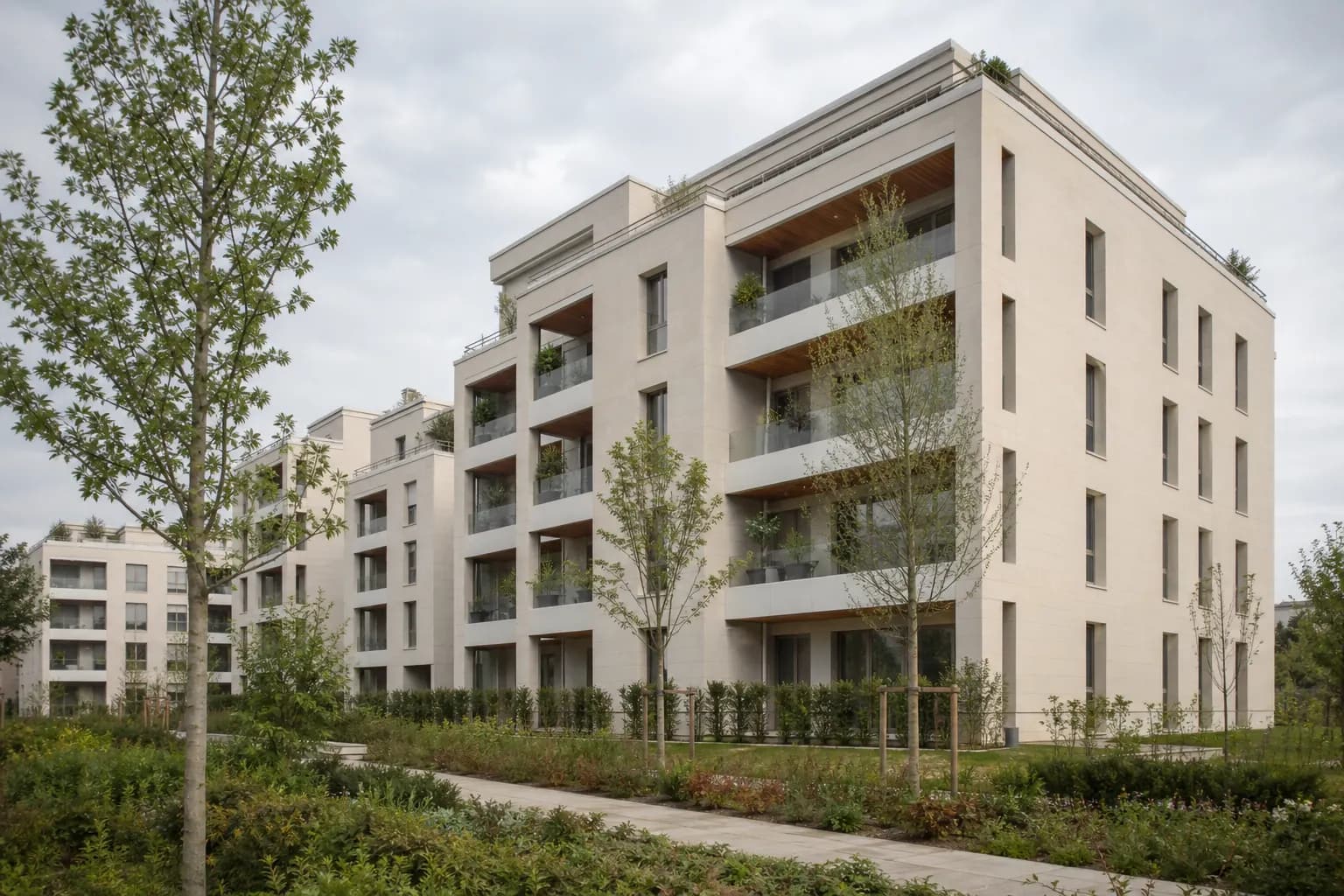 Une résidence neuve française aux balcons végétalisés, vue depuis son jardin paysager.
