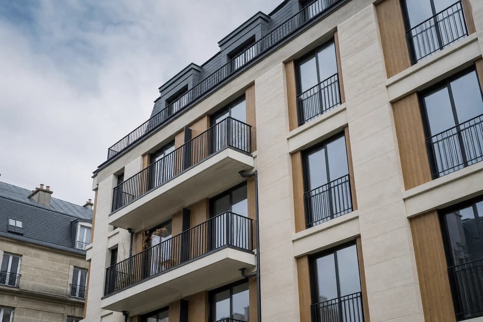 Les balcons superposés d'un immeuble d'habitation neuf, vus en contre-plongée.